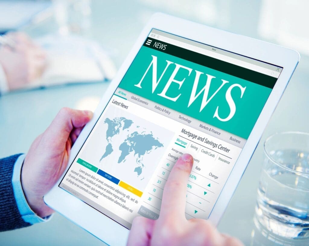 A person is holding an ipad with the news on it.