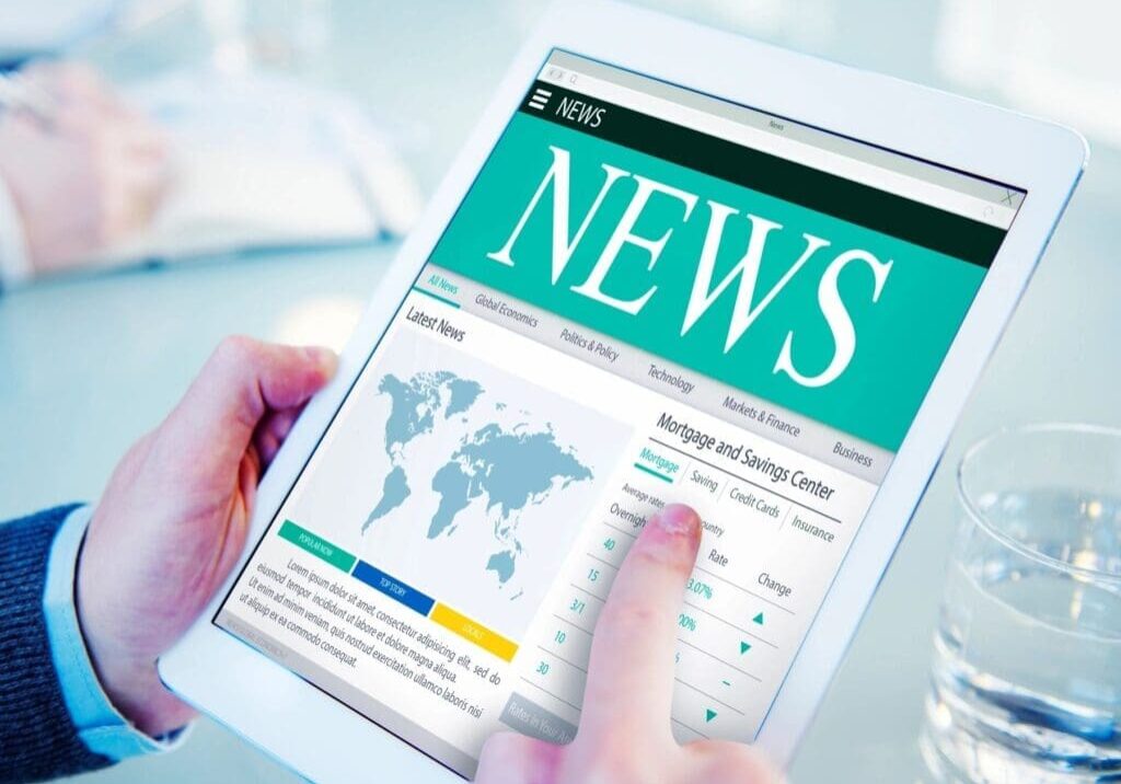 A person is holding an ipad with the news on it.
